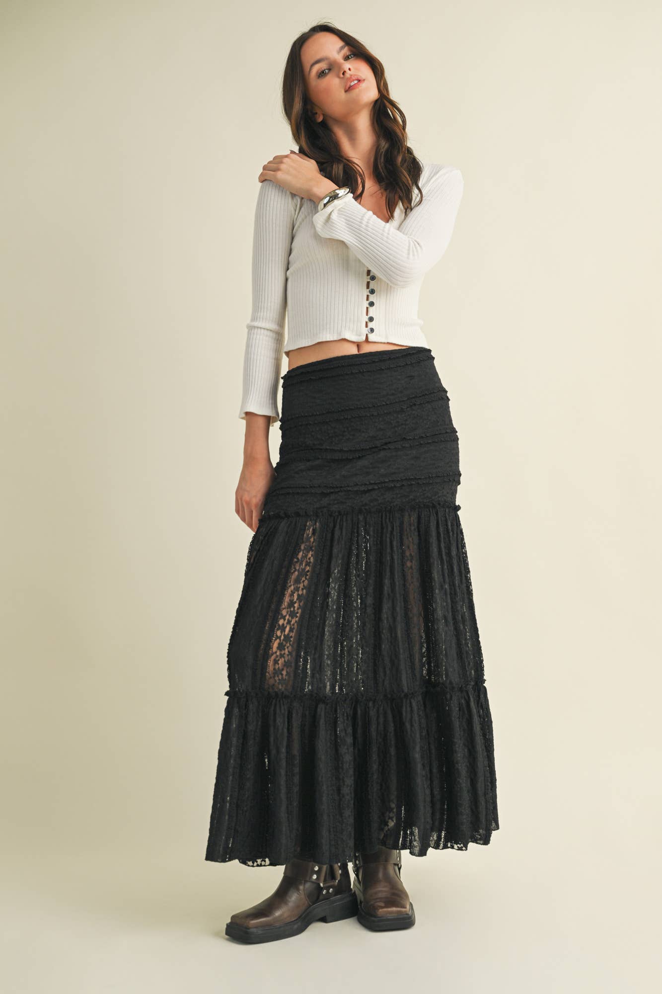 Woman wearing a white shirt and long black skirt.