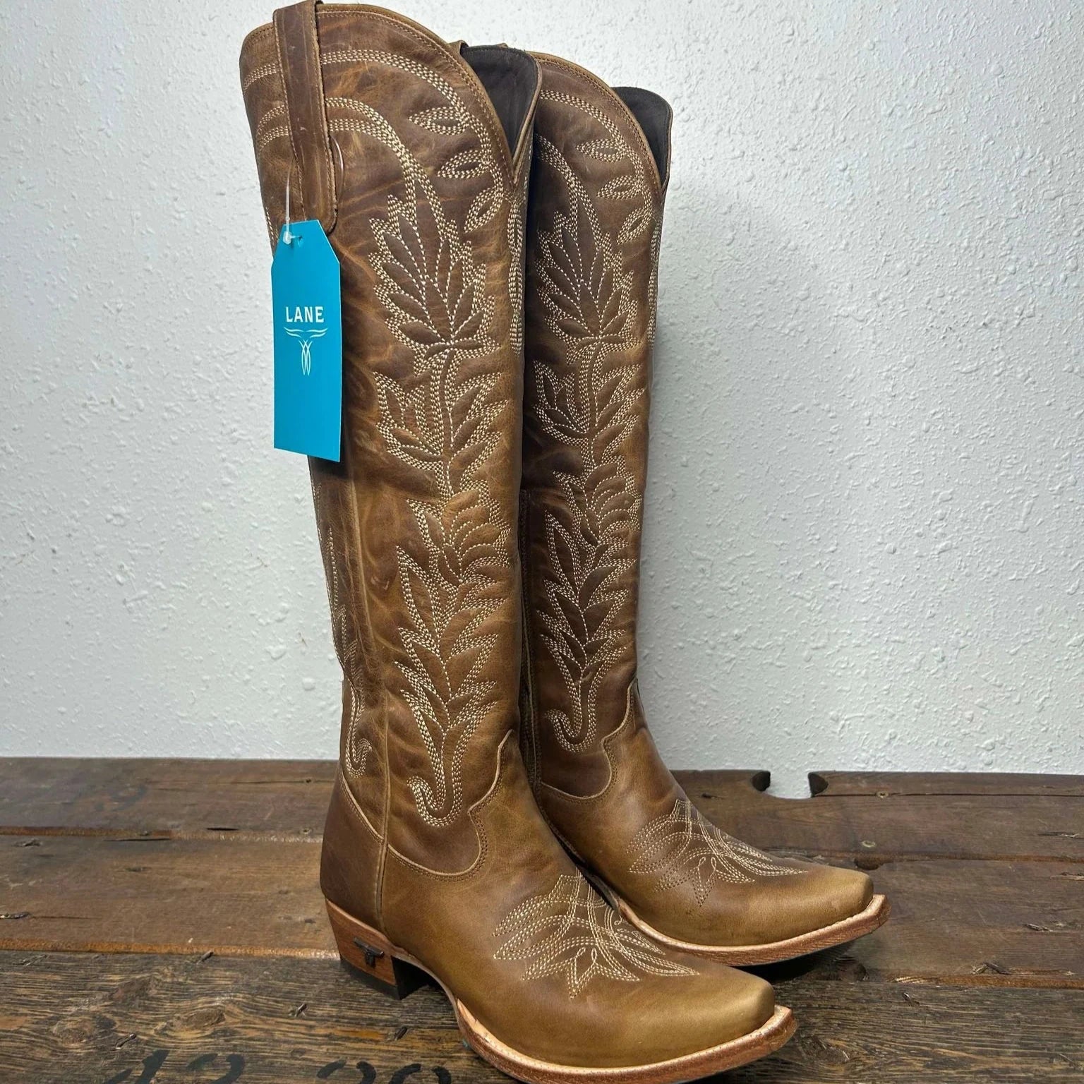 Brown leather cowboy boots with stitching.