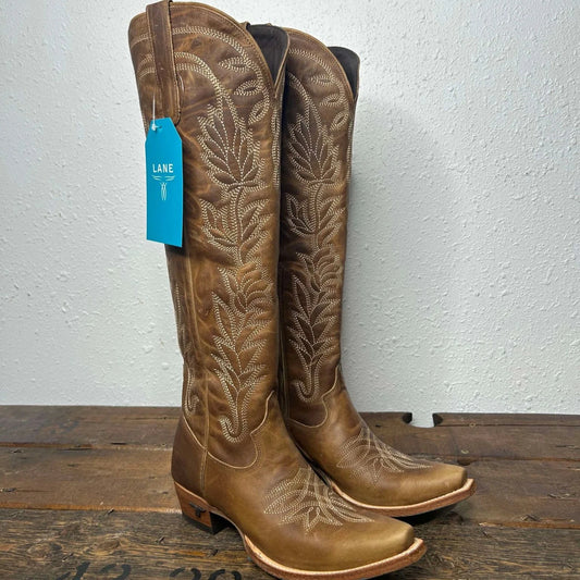 Brown leather cowboy boots with stitching.