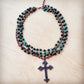 Necklace with cross pendant and turquoise beads.