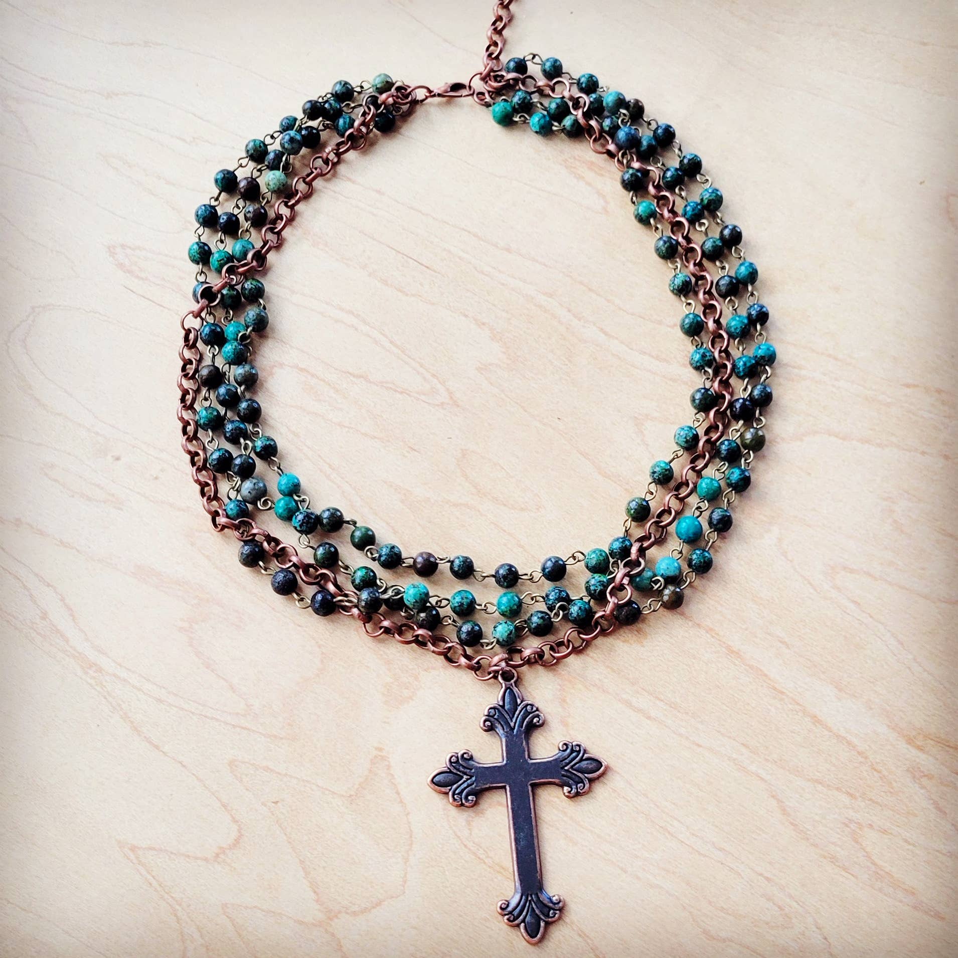 Necklace with cross pendant and turquoise beads.
