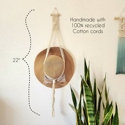 Hat in macrame hanger on wall.