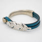 Blue leather bracelet with silver feather charm.