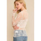 Woman wearing a sheer white lace top and jeans.