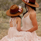 Woman and child in matching hats and dresses.