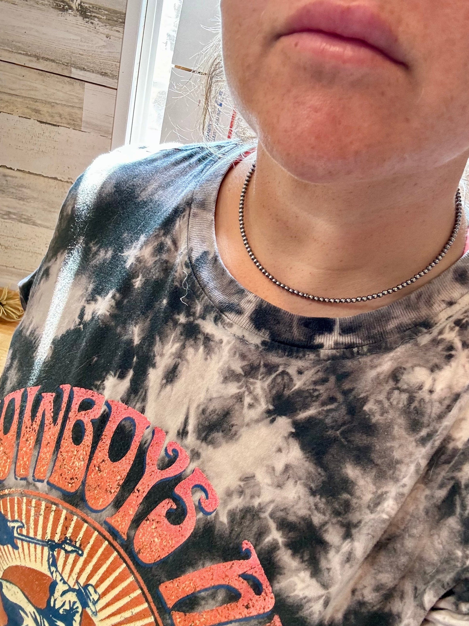 Cowboy tee with silver necklace, close-up