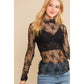 Woman in black lace top and jeans.
