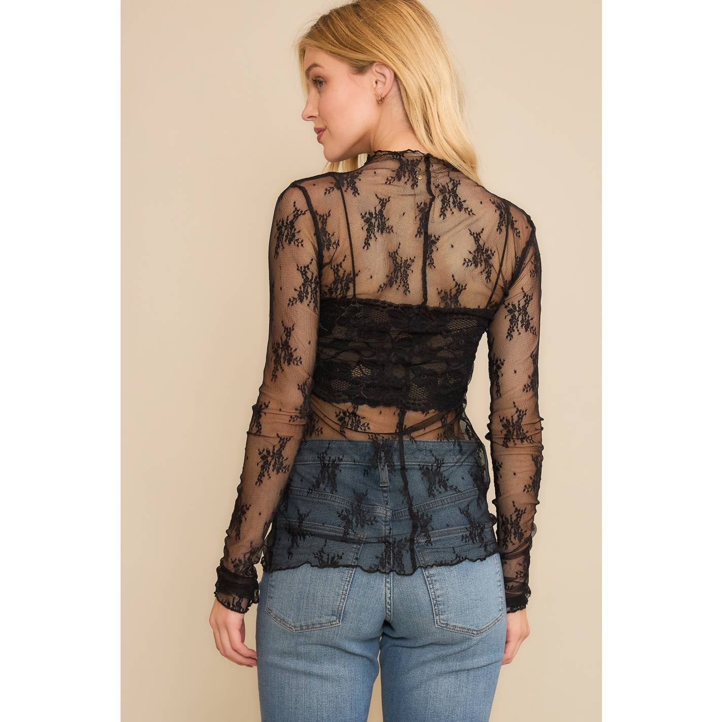 Woman in black lace top and jeans.