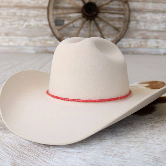 Cream-colored cowboy hat with red hatband.