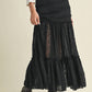 Woman in black lace skirt and boots.