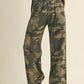 Person wearing camouflage pants and brown sweater.