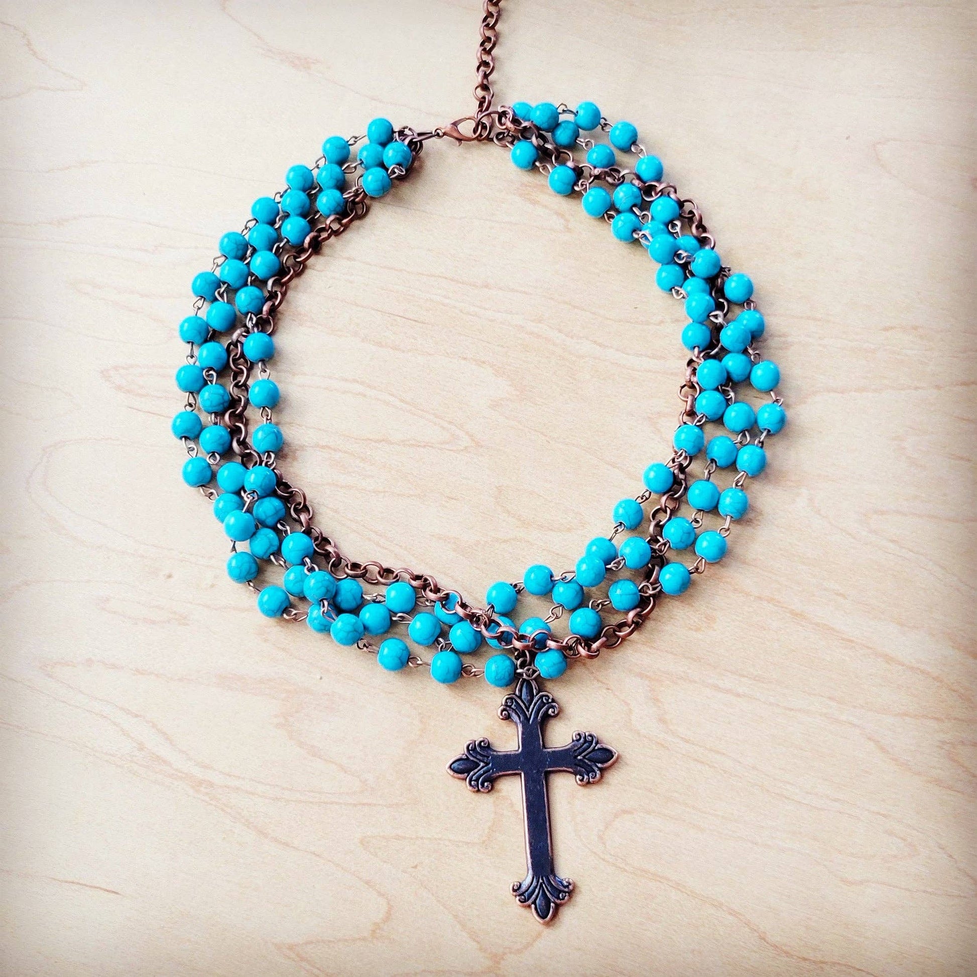 Turquoise beaded necklace with a cross pendant.
