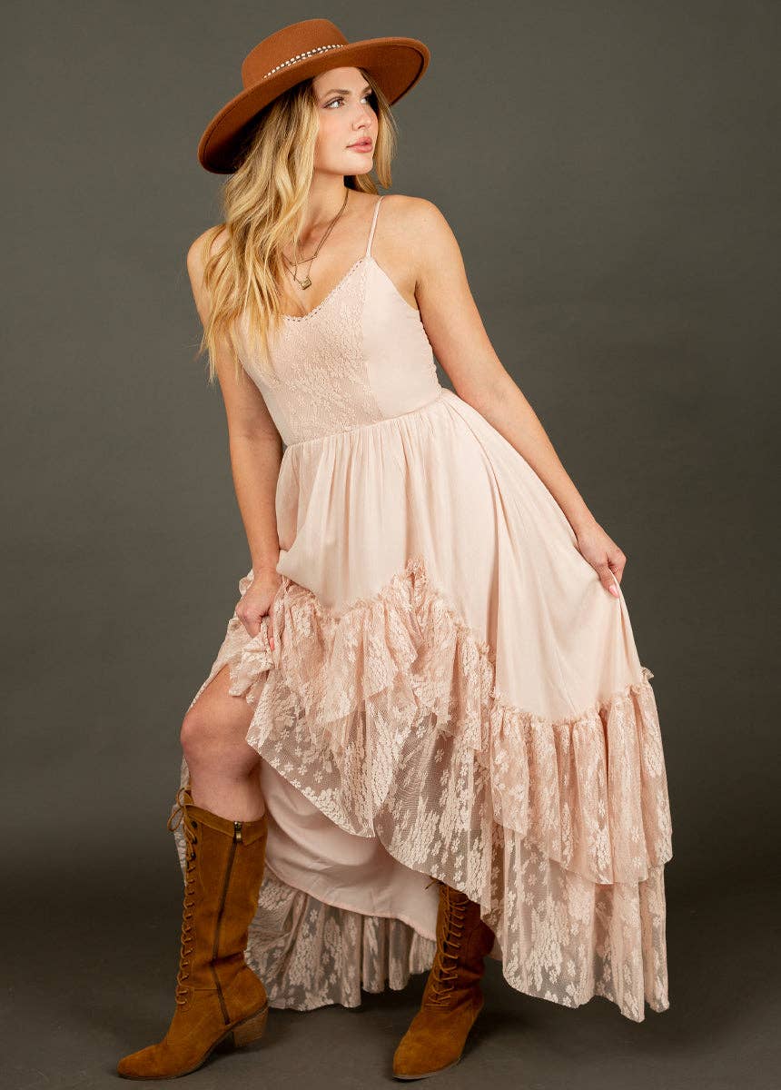 Woman in a pink dress and brown hat and boots.