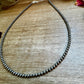 Hematite bead necklace on wood surface