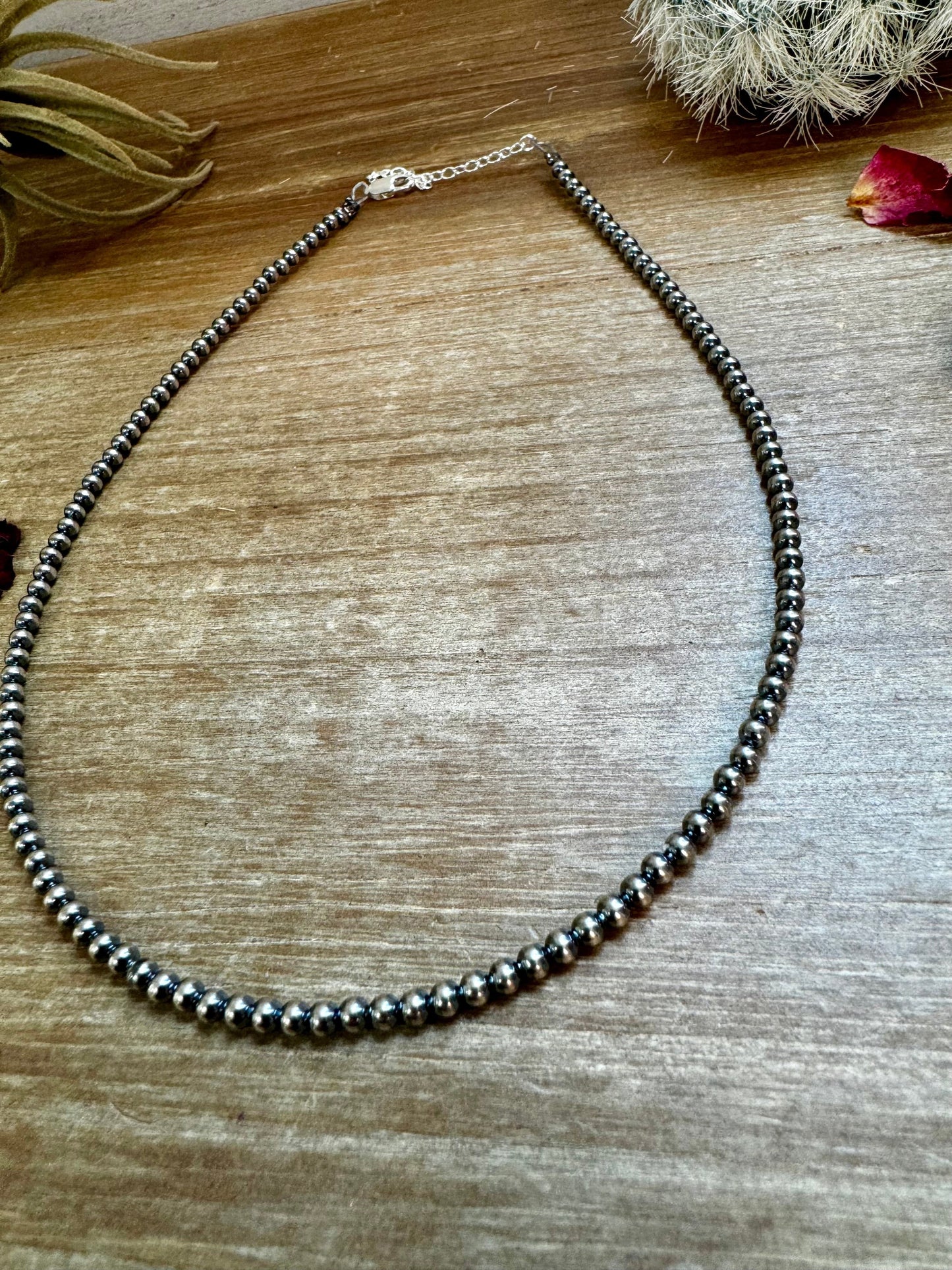 Hematite bead necklace on wood surface