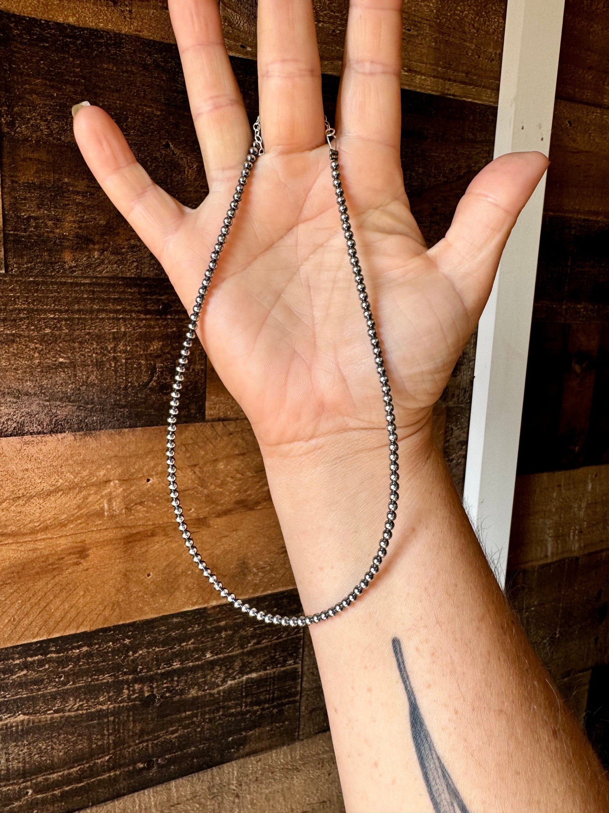 Necklace held in hand, CFBC9970-F8B5-482F-9D59-A4E003610AEE