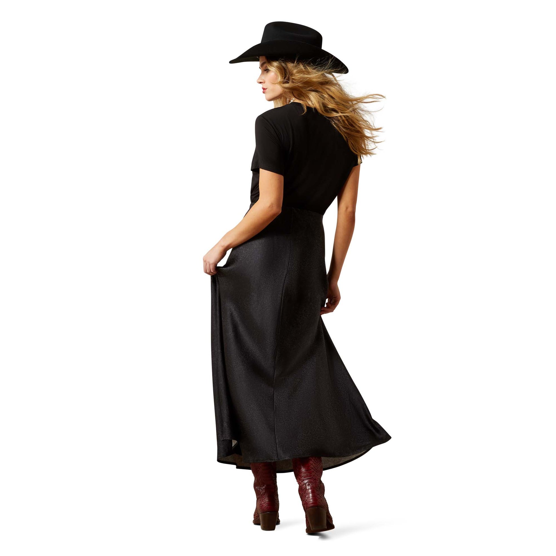Woman in black dress and hat, back view.