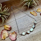 Necklace with stone beads on wood table