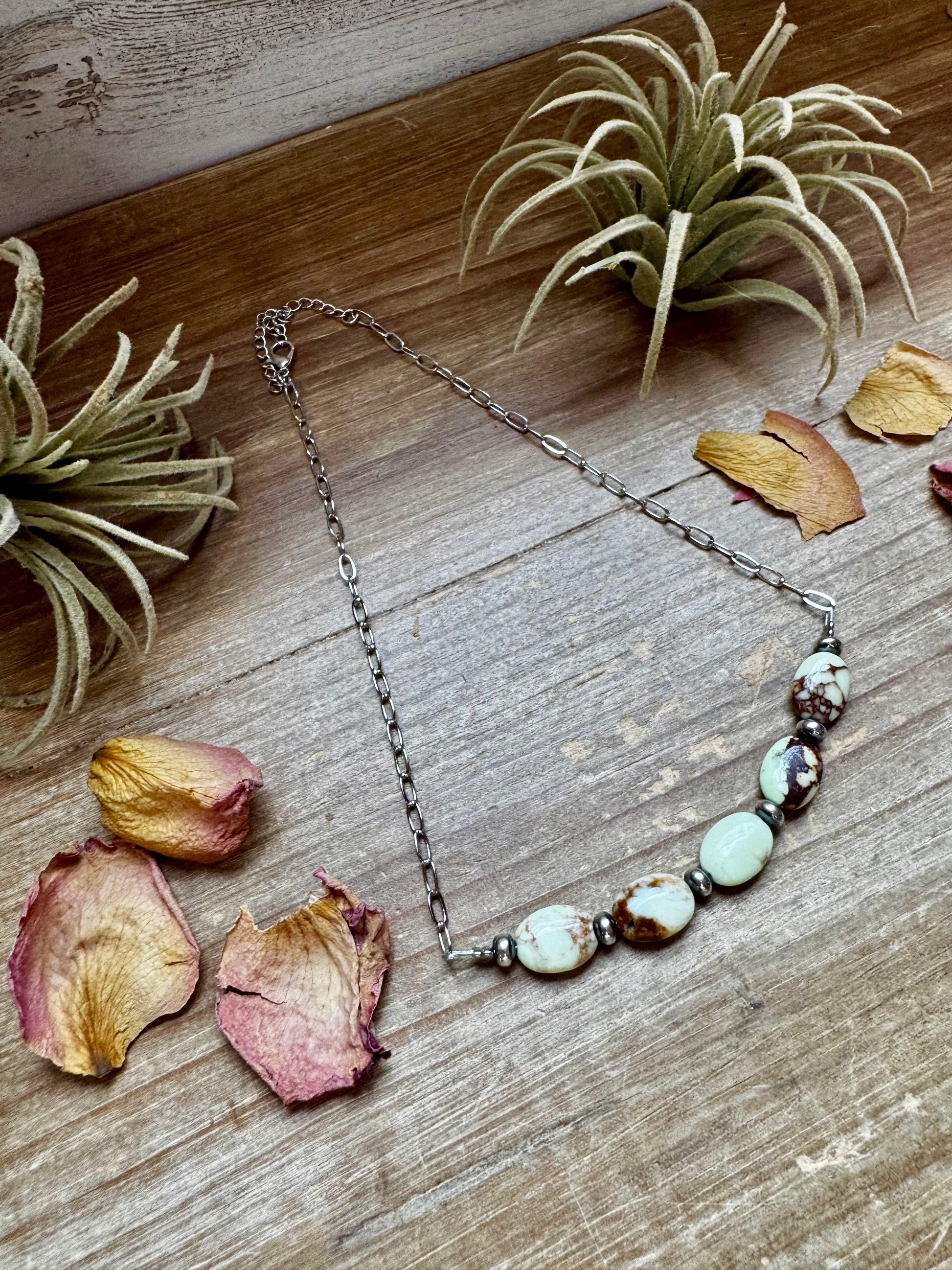 Necklace with stone beads on wood table