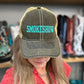 Person wearing a cap with 'SMOKESHOW' text in a store setting with boots and clothing in the background
