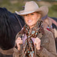 Cowgirl smiling in hat, scarf and jacket with horse.