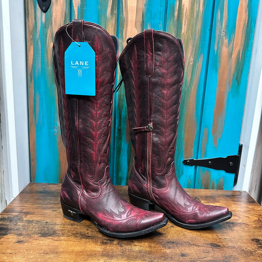 Pair of tall, red cowboy boots with tags.