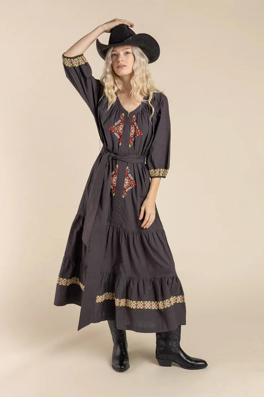 Woman in cowboy hat & embroidered dress.