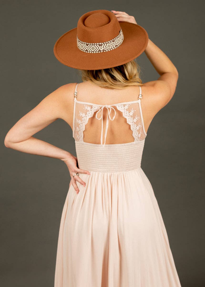 Woman in a dress and hat, back to camera.