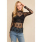 Woman in black lace top and jeans.