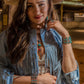 Woman in fringe jacket and jewelry, lifestyle image.