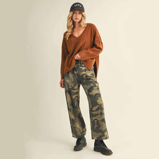 Woman in brown sweater and camo pants