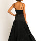 Woman in a black maxi dress, back view.