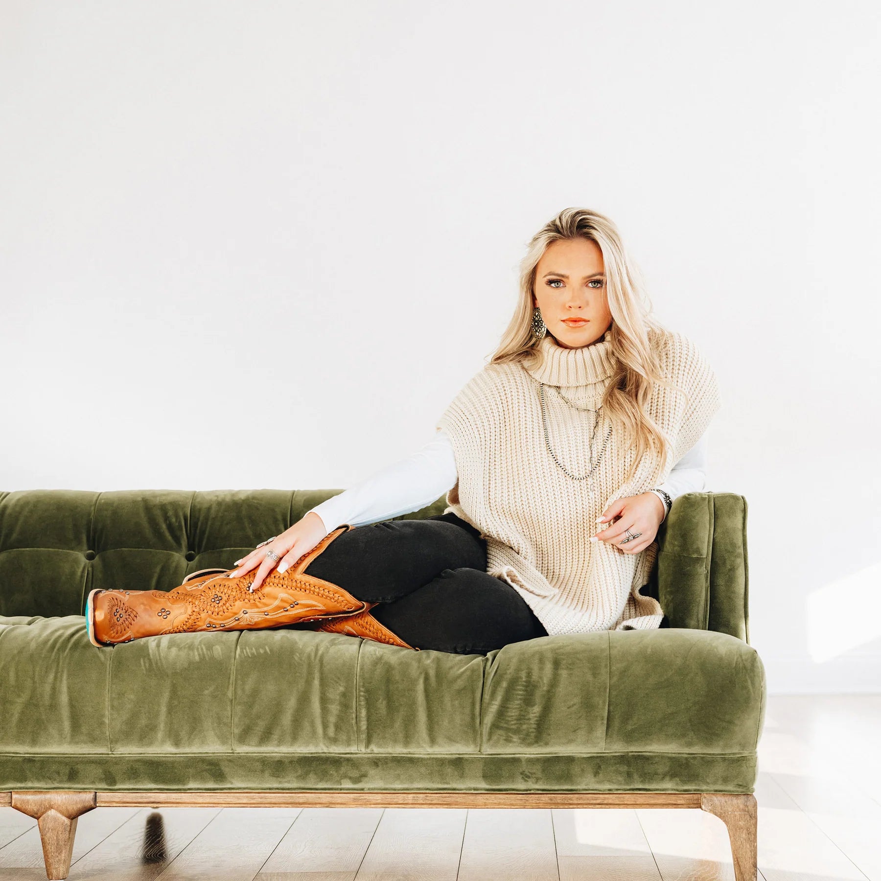 Cossette Saddle Boots & Sweater on Green Couch
