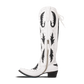 White and black Reverie cowboy boot on newsprint