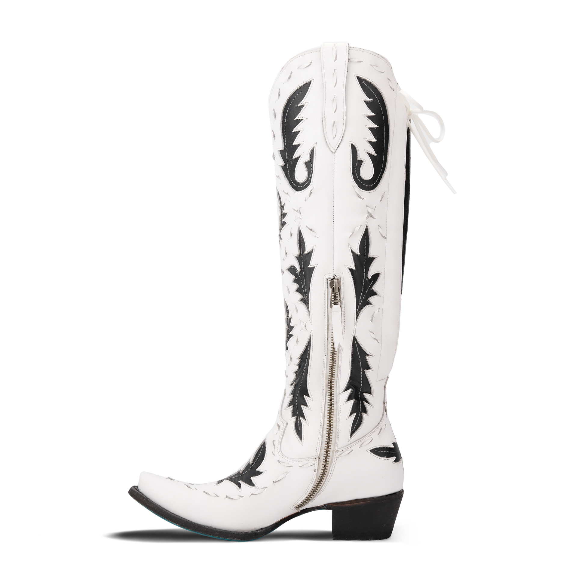 White and black Reverie cowboy boot on newsprint