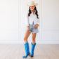 Woman in blue cowboy boots and white shirt