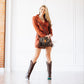 Woman in cognac dress & boots with fringe bag