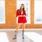 Woman in red blazer and washed denim boots