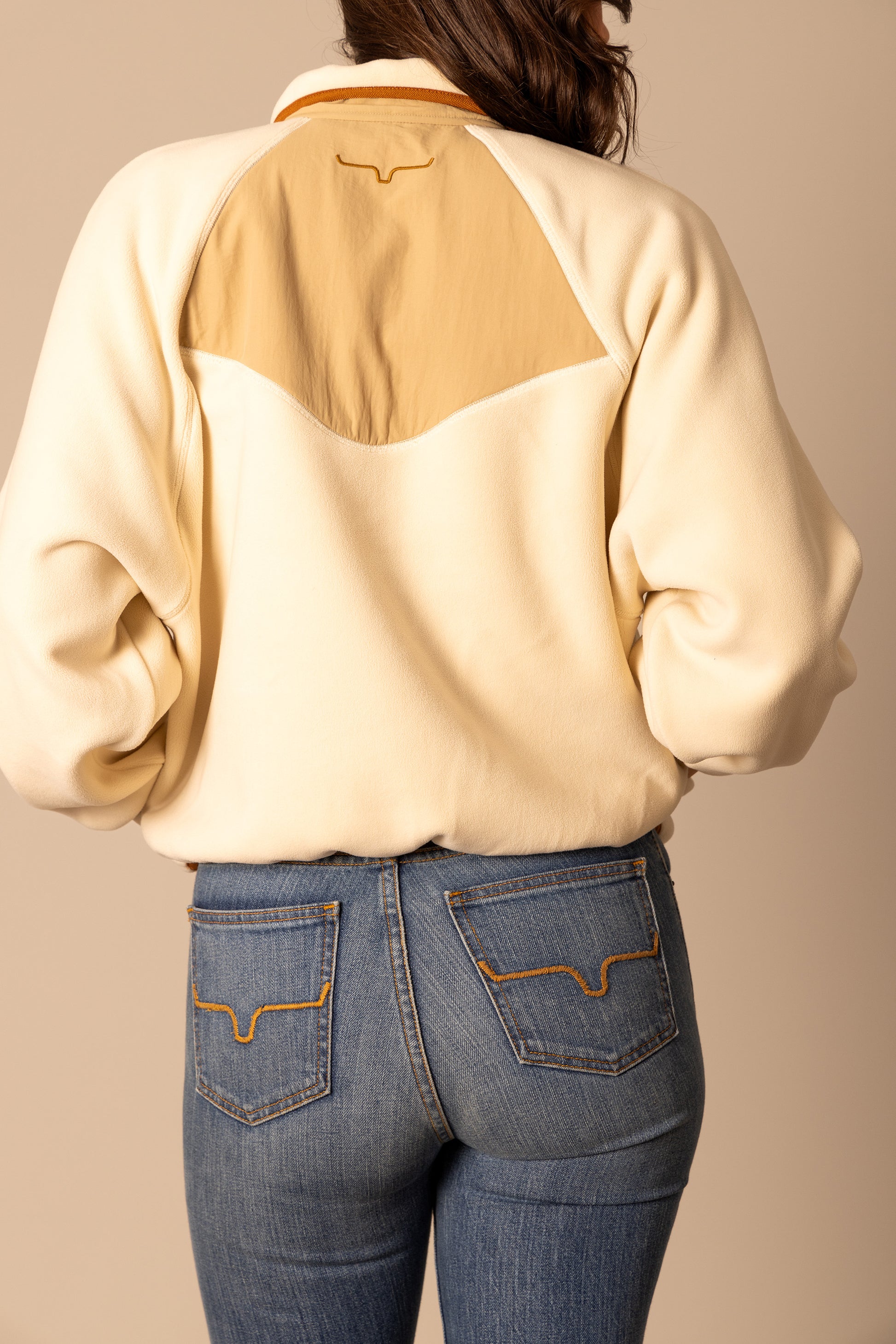 Woman wearing cream fleece jacket and jeans