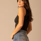 Woman in black tank top and jean shorts