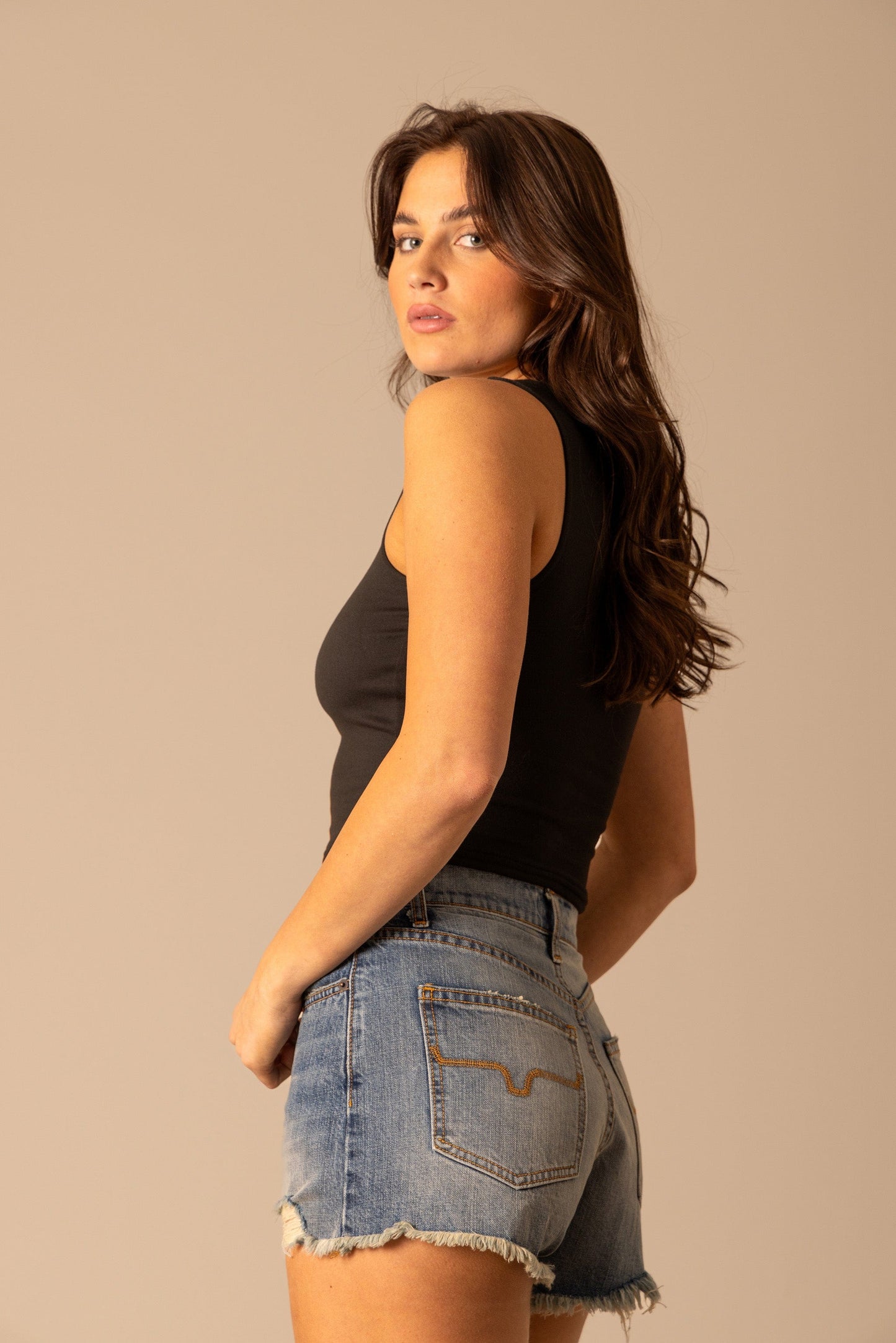 Woman in black tank top and jean shorts